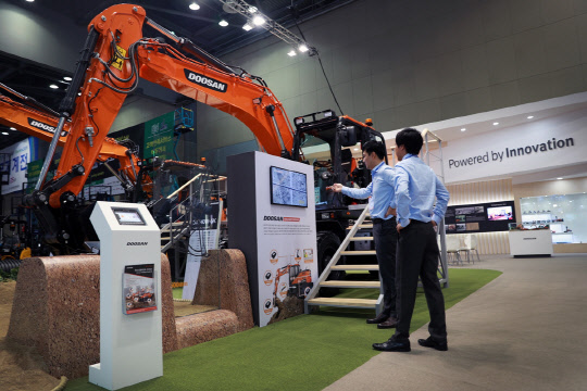 두산그룹은 22일부터 25일까지 일산 킨텍스에서 열리는 '한국산업대전'에 참가했다고 밝혔다. 사진은 행사에 참가한 두산인프라코어 부스에서 굴착기를 시연하고 있는 모습. <두산 제공>